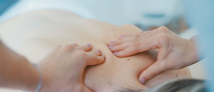 A photo of a person massaging ones back.